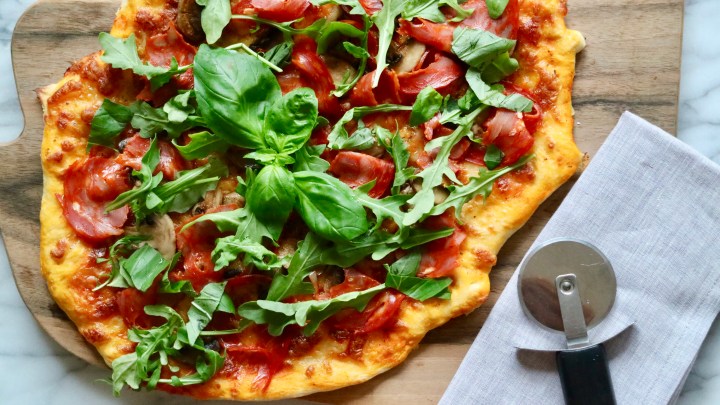 Pizza with salami, roasted mushrooms and arugula
