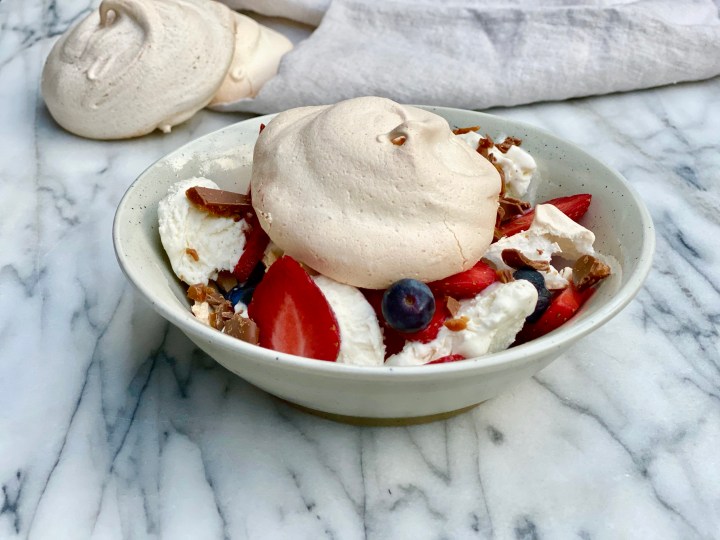 Meringue with strawberries, blueberries, vanilla ice cream and Daim cross